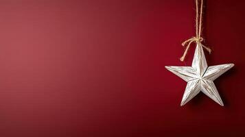 single star ornament hanging on deep red background, creating festive atmosphere photo