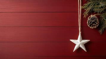 star ornament hanging on deep red background with pinecones and greenery photo