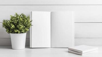 blank magazine lies open beside potted plant on white table photo