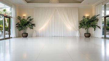 Elegant white curtain backdrop with potted plants in spacious venue photo