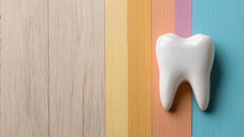 white tooth model on colorful wooden background, symbolizing dental health photo