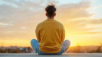 person sitting peacefully at sunset, reflecting on life and emotions photo