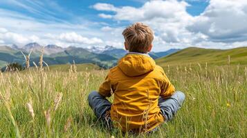 child sitting in grassy field, observing nature and enjoying scenery photo