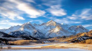 Dusk over mountain range with snow and vibrant clouds creates serene landscape photo