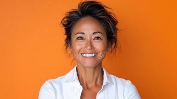 A woman smiling in front of an orange background photo
