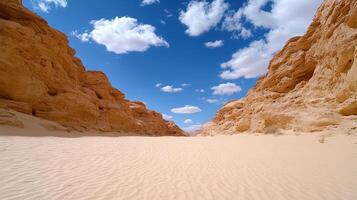 vast desert landscape with sandy terrain and rocky formations under blue sky photo