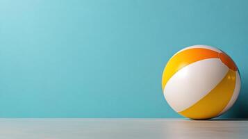 Colorful beach ball isolated on bright turquoise background, evoking summer fun photo