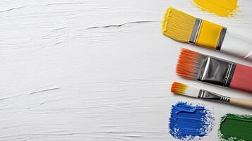 Colorful paintbrushes arranged on textured white background, perfect for art photo