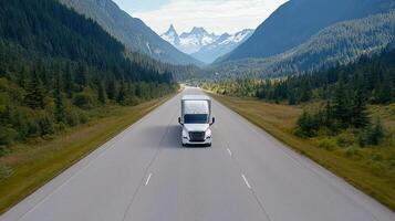 Driving logistic truck on highway surrounded by mountains and trees photo