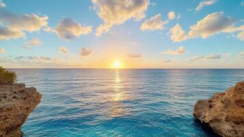 Breathtaking sunset over calm ocean waters with rocky cliffs photo