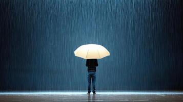 A person standing under an umbrella in the rain photo