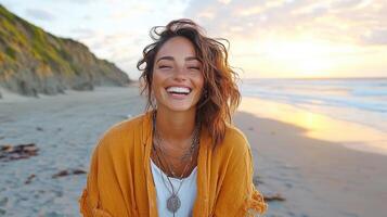 joyful woman with radiant smile stands on beach at sunset, wearing orange shawl photo