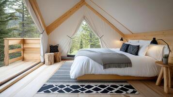 spacious glamping tent featuring cozy bed, wooden furniture, and nature views photo