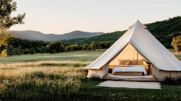 glamping tent in meadow surrounded by wildflowers and mountains photo