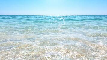 Crystal clear ocean water with gentle waves and bright sunlight photo