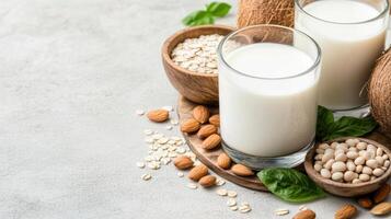 Milk, almonds, coconut and oats on a table photo