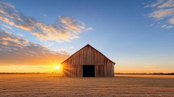 A barn in a field at sunset photo