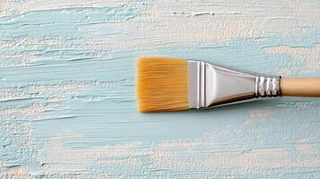 A paint brush on a blue painted wall photo