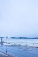 wet road at embankment of frozen river in Kostroma photo