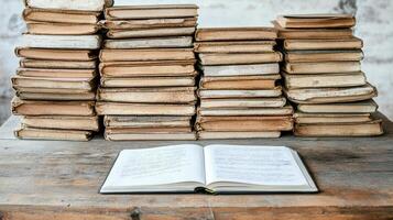 An open book on a table with stacks of old books photo