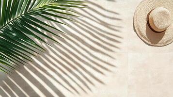 tropical scene featuring palm leaf casting shadows on light background with straw hat photo