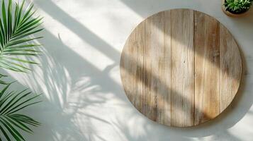 round wooden table with shadows and plant in bright setting photo