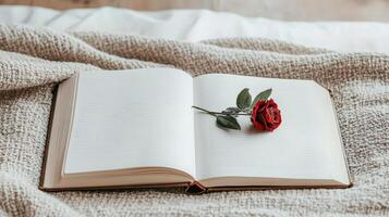 close up of open diary with red rose resting on its pages, evoking romance photo
