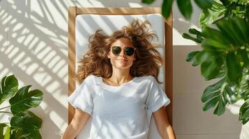 woman relaxing on sunbed surrounded by lush greenery, enjoying sun photo