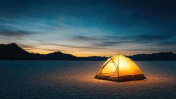 glowing tent stands alone in vast desert landscape at dusk photo