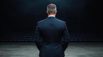 confident CEO in suit standing on stage, ready to inspire audience photo