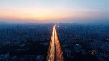 Aerial view of city skyline at sunset with light trails on highway photo
