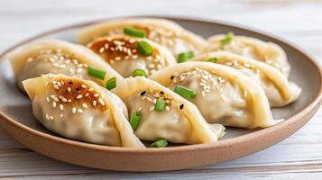 Deliciously arranged plate of freshly steamed dumplings garnished with sesame seeds and green photo