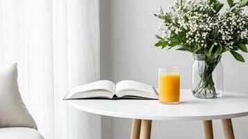 clean white breakfast table with glass of orange juice, book, and fresh flowers creates serene photo