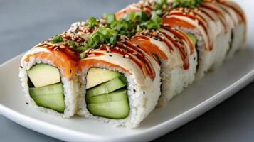 Delicious gourmet sushi roll featuring fresh cucumber, avocado, and drizzled sauce photo