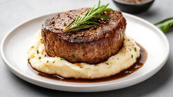 gourmet steak dish served creamy mashed potatoes, garnished with herbs, and drizzled with sauce photo