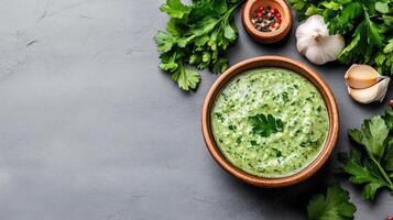 Homemade green sauce with fresh herbs, garlic, and spices in rustic bowl photo