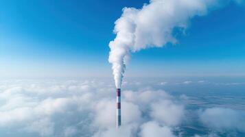 Aerial view of smokestack emitting white smoke into clear blue sky, highlighting air pollution photo