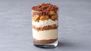 Delicious tiramisu parfait layered with cream, cookies, and cocoa powder photo