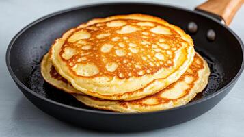 Fluffy pancakes stacked in frying pan, golden brown and ready to serve photo