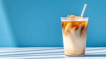 refreshing iced coffee drink with beautiful swirl of cream against blue background photo