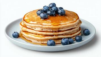 Fluffy pancakes stacked high, drizzled with syrup and topped with fresh blueberries photo