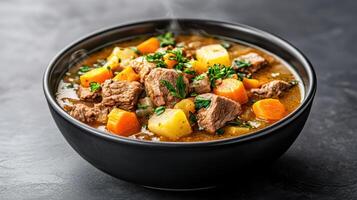 steaming bowl of hearty beef and vegetable soup filled with tender meat and fresh ingredients photo