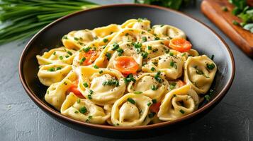 Colorful pasta dish featuring tri color tortellini, garnished with herbs and spices photo