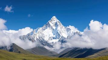Majestic mountain peak surrounded by clouds and lush green valleys, showcasing nature beauty photo