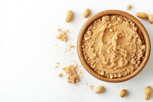 Creamy peanut butter in a wooden bowl surrounded by peanuts photo