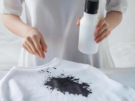 Woman applying black dye on a white t-shirt with care photo