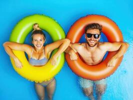 Couple enjoys summer fun in colorful pool floats on a sunny day photo