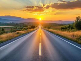 Sunset over a winding road with rolling hills in the background photo