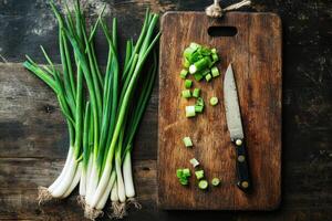 Fresh green onions sliced on a wooden cutting board photo