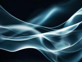 Abstract wisps of blue smoke flowing gracefully in darkness photo